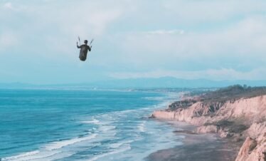 a person is parasailing over the ocean on a sunny day
